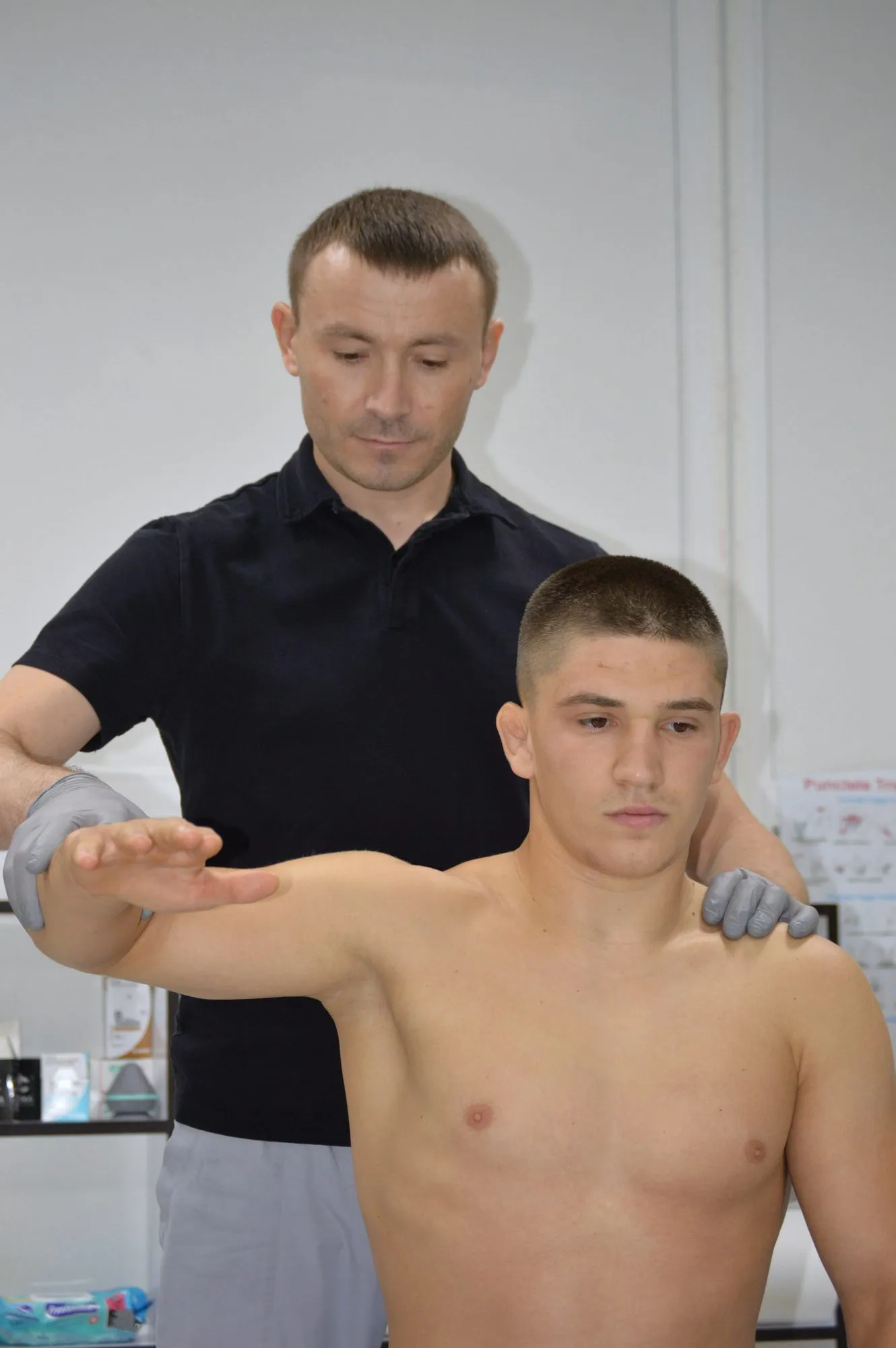 Kinetoterapeut testând amplitudinea de mișcare a umărului unui pacient, în cabinetul Modkinetic din Ungheni.